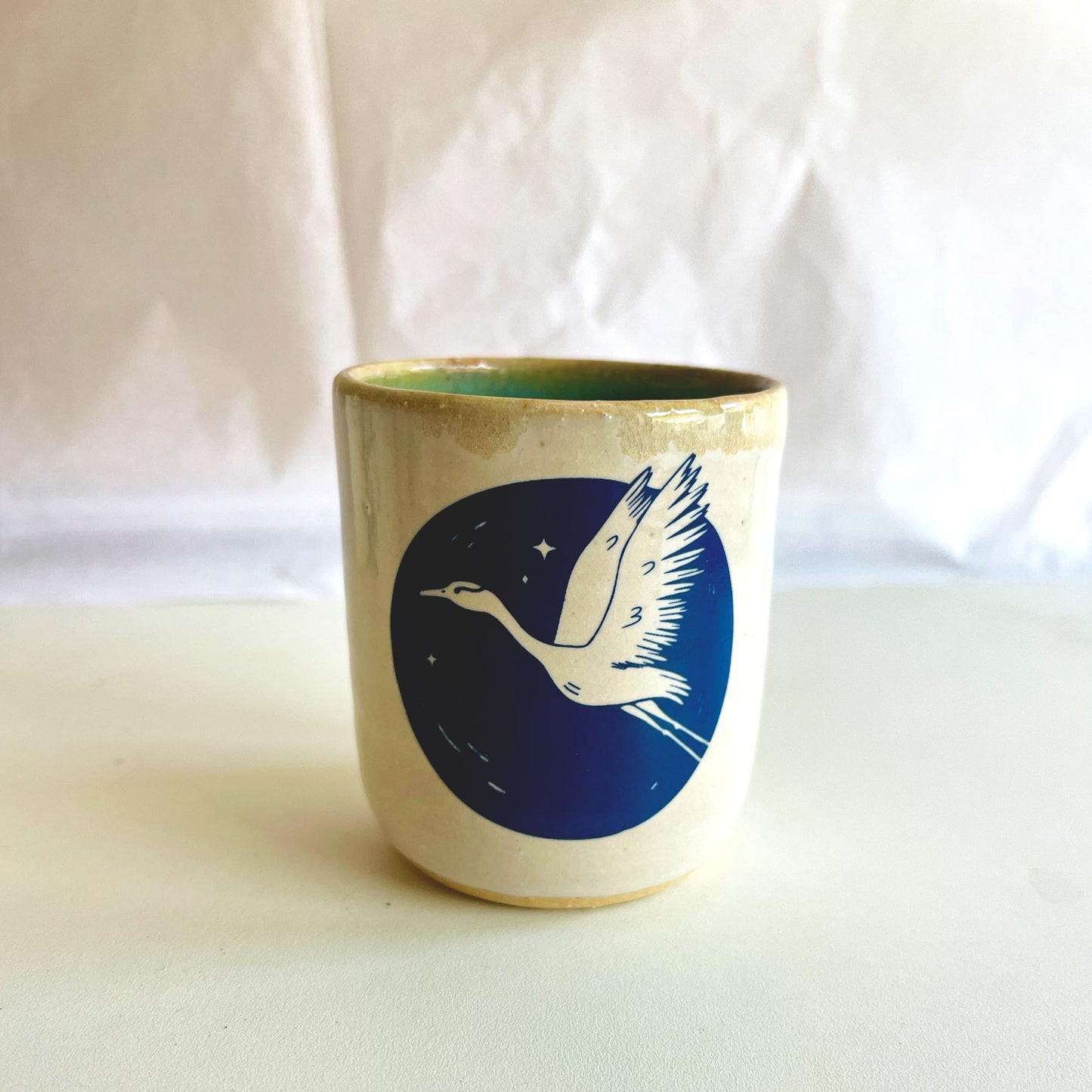 Ceramic cup with a blue design of a bird on a white background