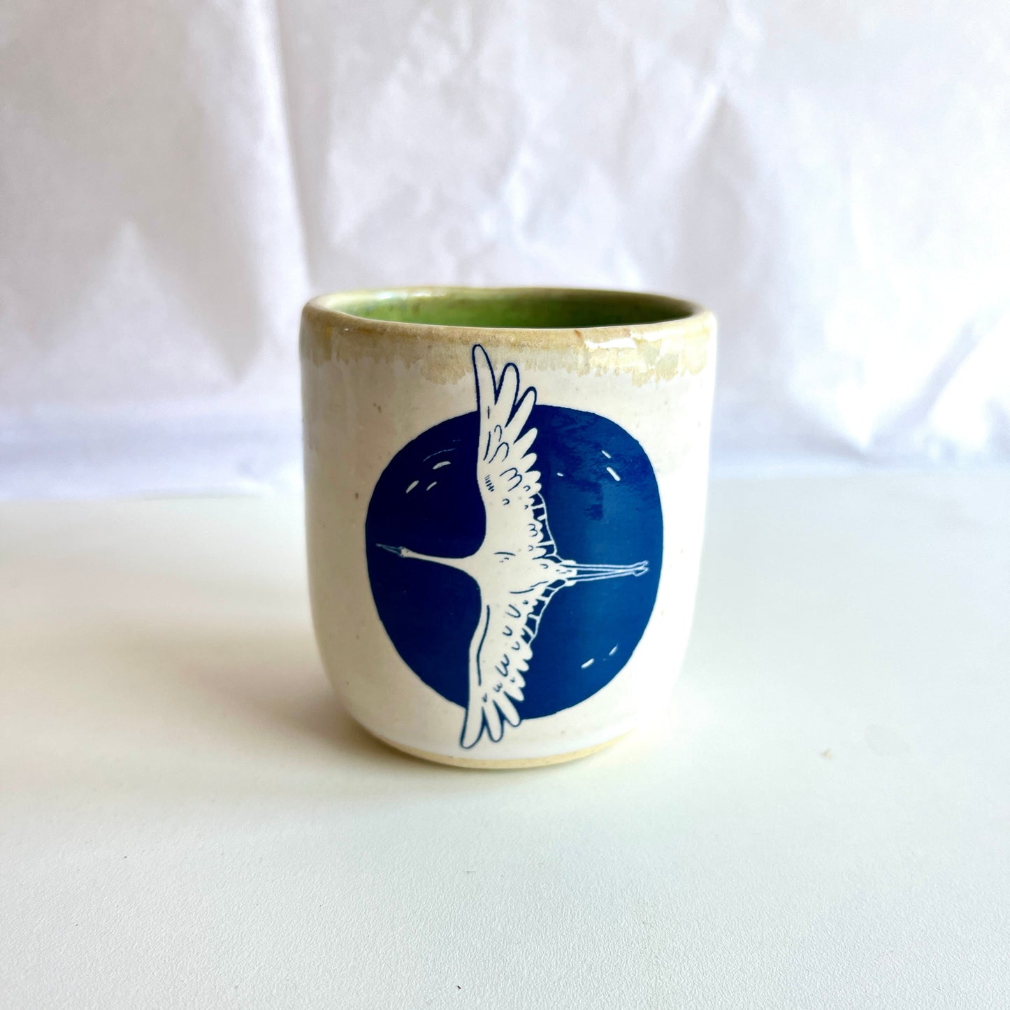 Ceramic cup with a blue design of a bird on a white background