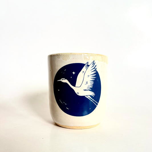 Ceramic mug with a blue design of a bird and stars on a white background