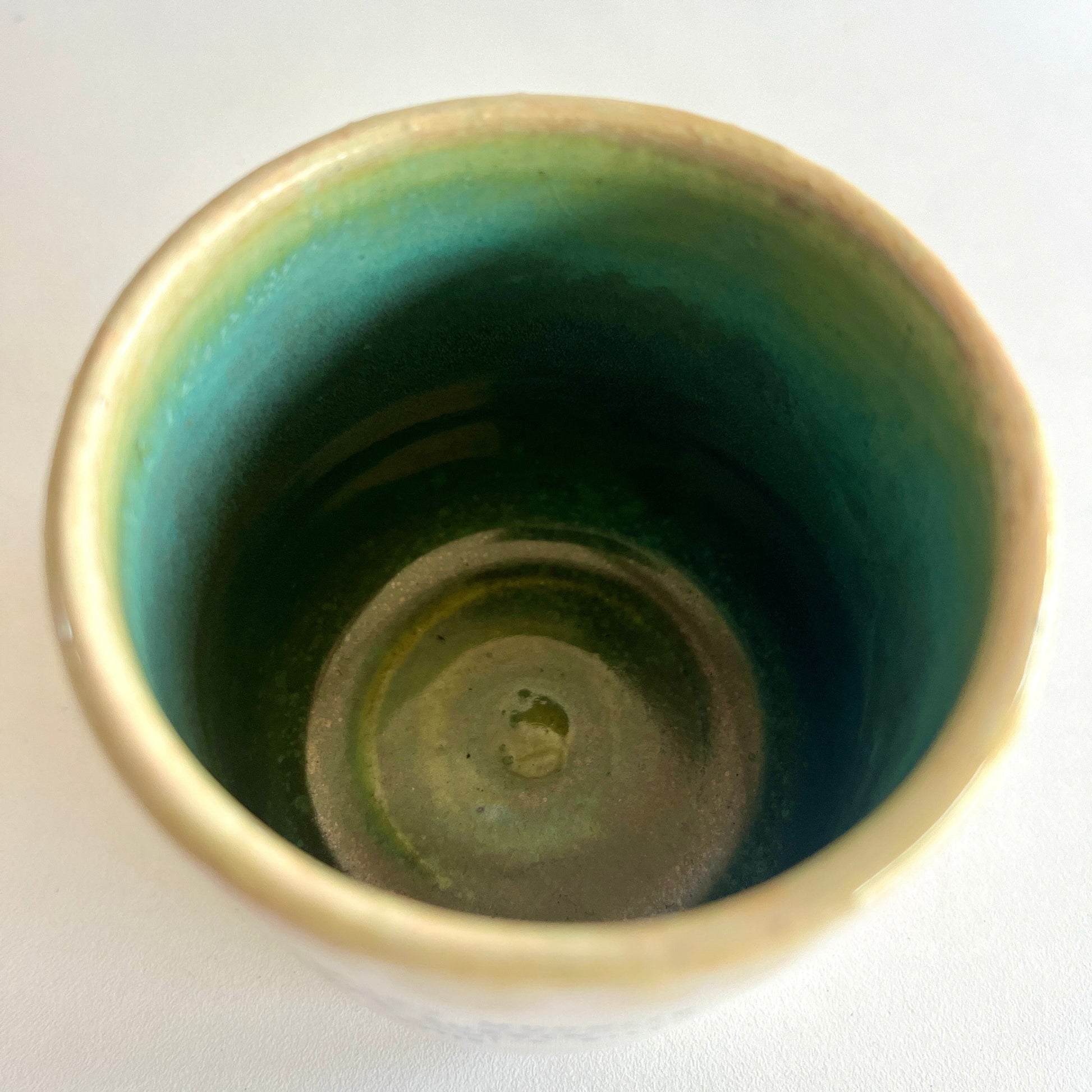 Green ceramic cup on a white background