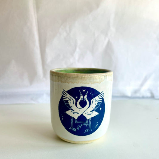 Ceramic cup with a blue design of a bird on a white background